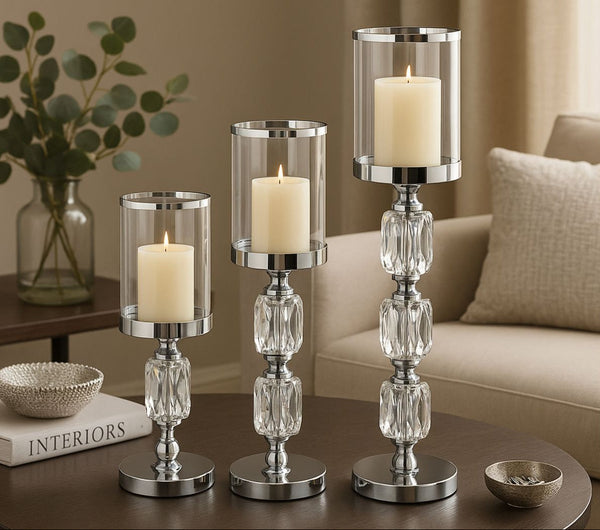 Set of three crystal candle holders with candles on a coffee table in a living room setting.