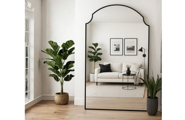 Large Adair arch mirror in modern living room reflecting sofa, wall art, plants and décor.