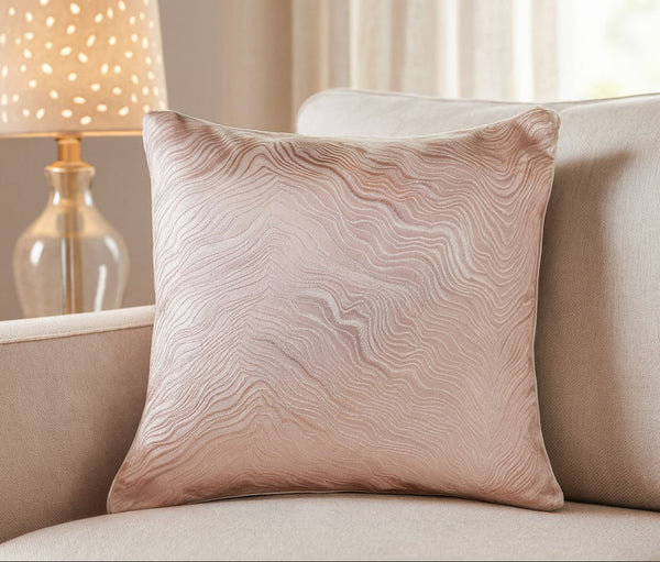 Textured beife and gold cushion on a beige sofa with a soft-focus background