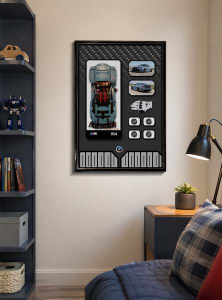 Framed artwork on a wall above a bed with a nightstand and lamp.