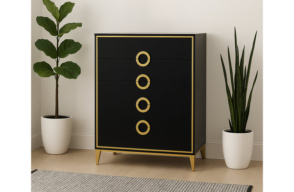 Black Balmain tallboy with gold trim styled between indoor plants in a modern bedroom setting.