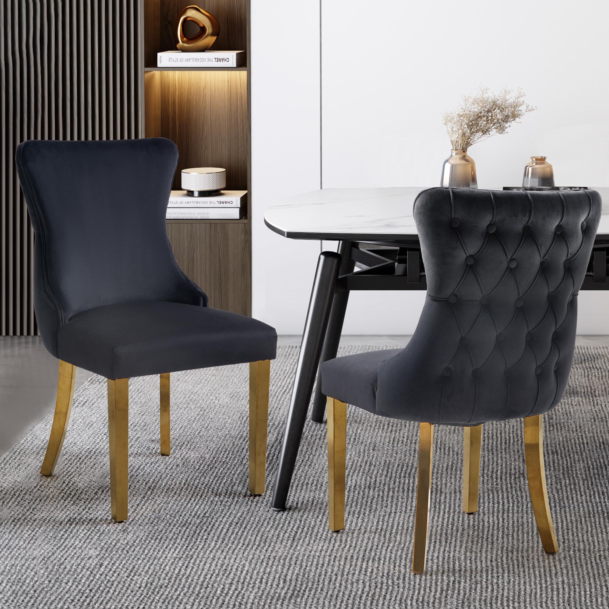 Pair of black velvet Paris dining chairs with gold legs styled in a modern room.
