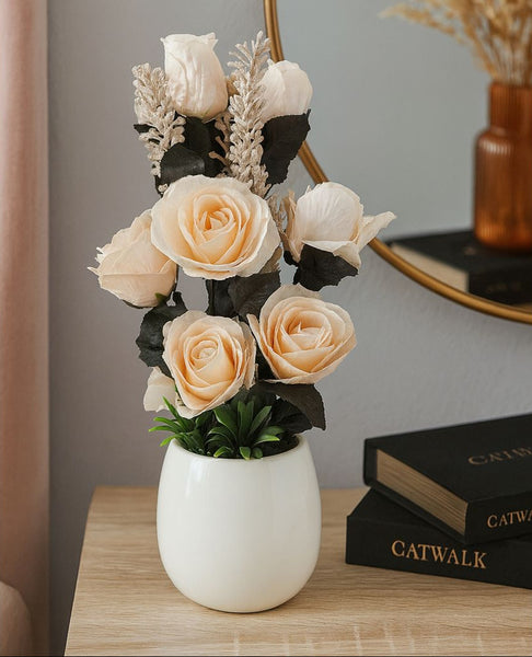 Floral arrangement in a white vase on a wooden surface with a blurred background