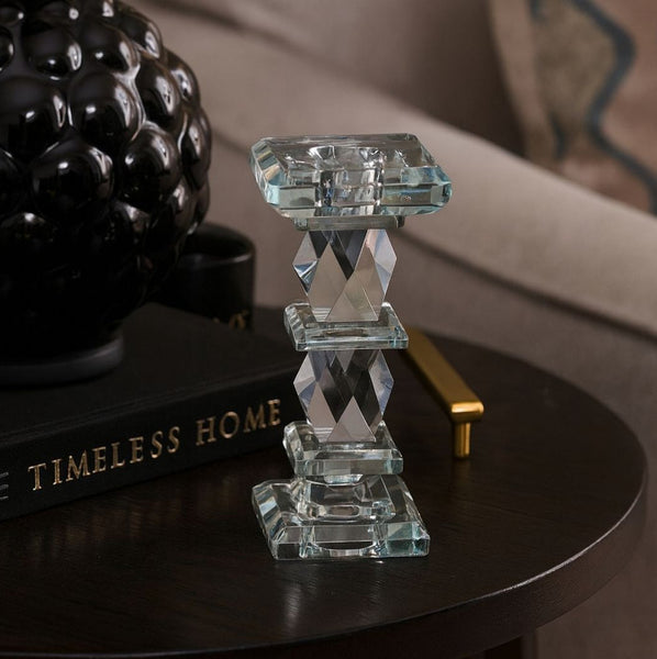 Crystal candle holder on a dark surface with 'Timeless Home' book