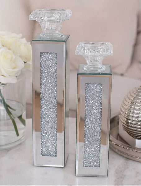 Two decorative candles with crystal embellishments on a light surface.