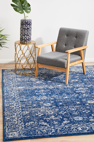 Evoke 252 Navy Rug styled in living room with grey chair and gold side table