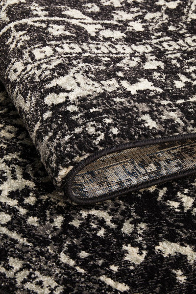 Folded edge of Evoke Charcoal Rug highlighting dense weave