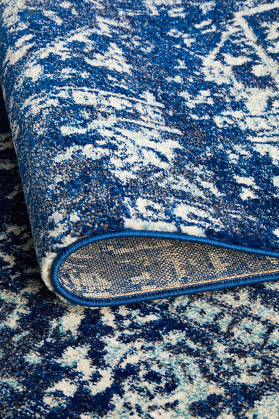 Folded view of the Evoke 253 Navy Rug showcasing its thick, durable weave and detailed Persian-inspired pattern in navy and off-white.