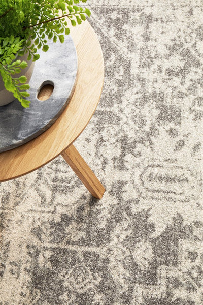 Close-up of white silver rug detail with side table décor