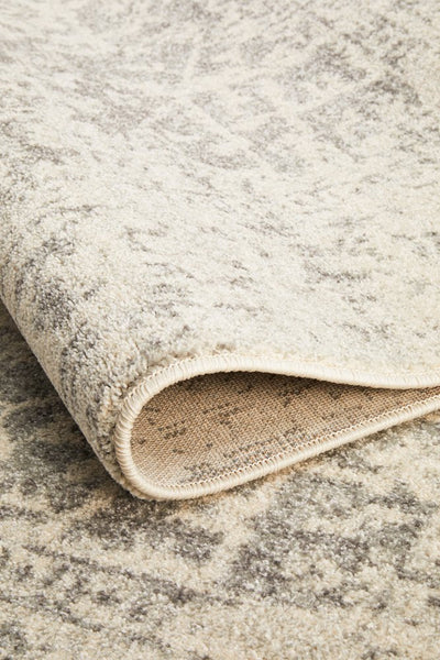 Folded corner of white silver rug showcasing weave and texture