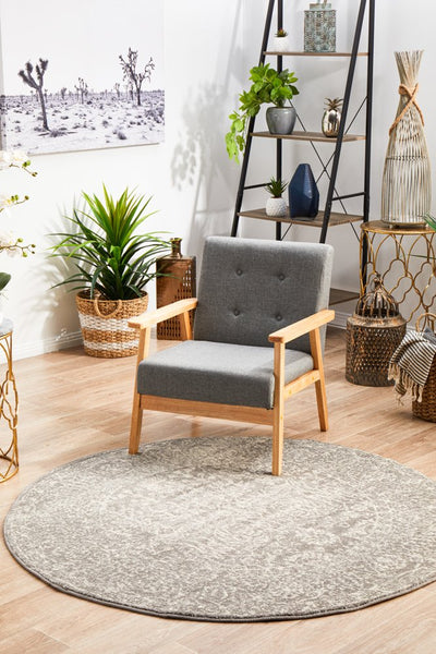 Evoke 256 Grey round rug styled with modern grey armchair and indoor plants.