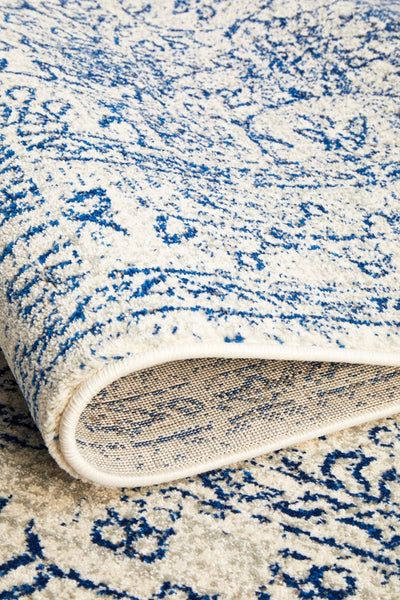 Folded rug edge highlighting plush pile, navy distressed design, and durable woven backing structure.