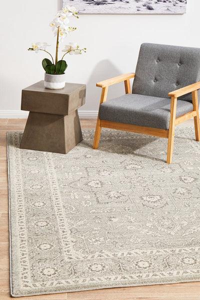 Stylish grey and silver rug styled with armchair and side table in a cozy setting.