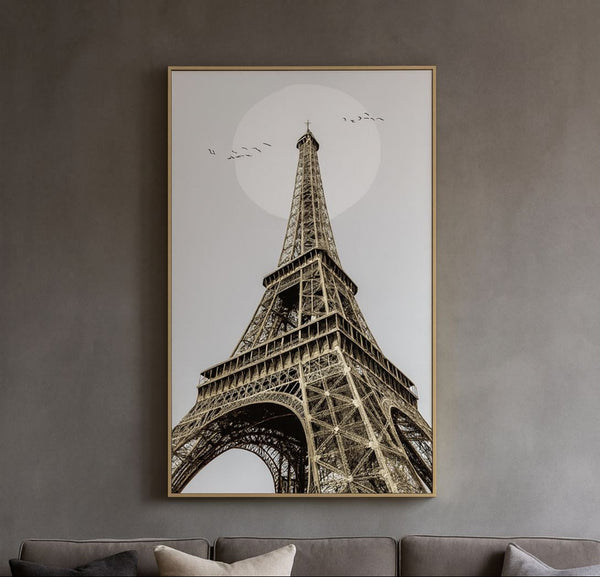 Framed artwork of the Eiffel Tower on a gray wall above a sofa.