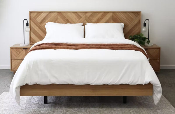 Esta herringbone bed frame styled in modern bedroom with matching bedside tables and white bedding.