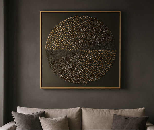 Decorative gold wall art with circular design on a dark wall above a sofa.