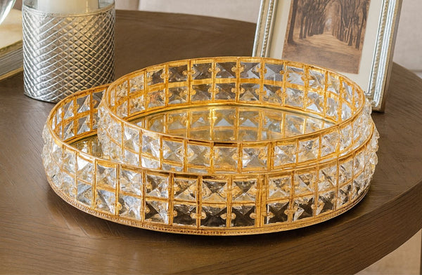 Decorative glass bowl with gold crystal mirror tray set on a wooden surface.