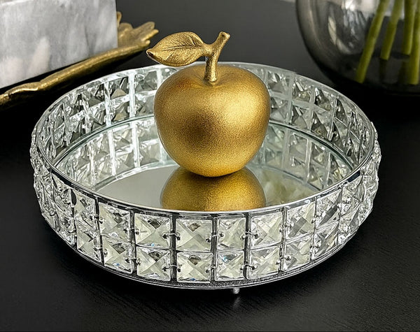 Decorative crystal mirror tray with a gold apple on a black surface