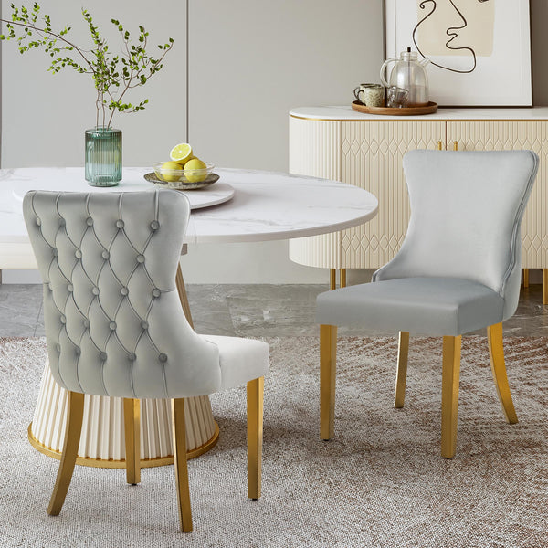 Light grey velvet Paris dining chairs with gold legs arranged in a cozy modern dining room.
