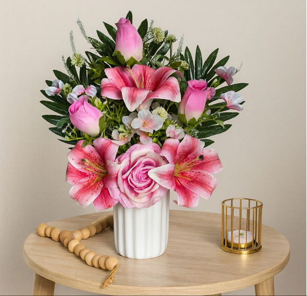 Bouquet of pink flowers in a white vase on a wooden table with a neutral background
