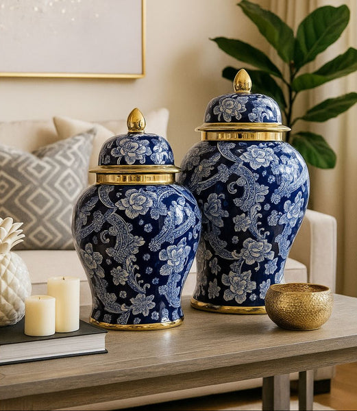 Two blue floral-patterned vases with gold accents on a table in a room setting.