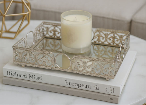 Decorative metal rectangle tray with a candle on top of books