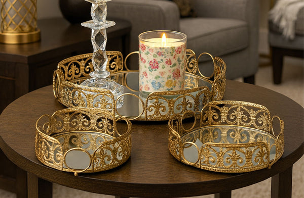 Decorative gold round tray with a candle holder on a wooden table with a candle.