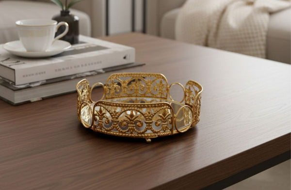 Decorative gold round tray on a wooden table with a blurred background