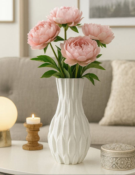 White 3d vase with pink flowers on a coffee table in a living room setting