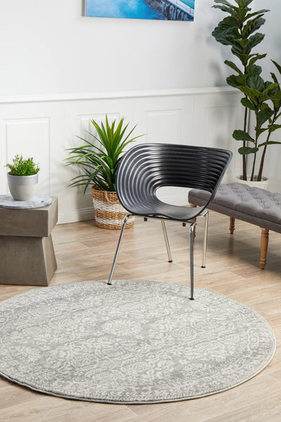 Round Mirage 358 Silver Rug styled with modern black chair and indoor plants