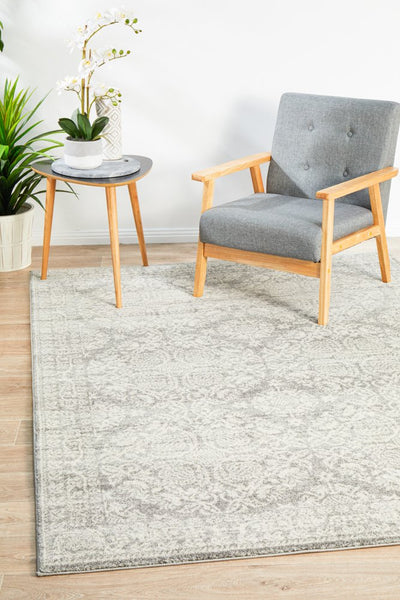 Mirage 358 Silver Rug styled in a modern living room with a grey chair and wooden side table.