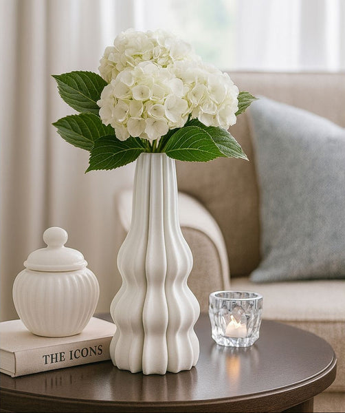 White vase with flowers on a table in a living room setting