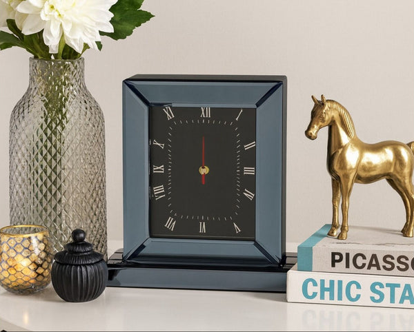 Decorative Mirrored Smoke Grey clock on a shelf with a vase, candle, and gold horse statue.