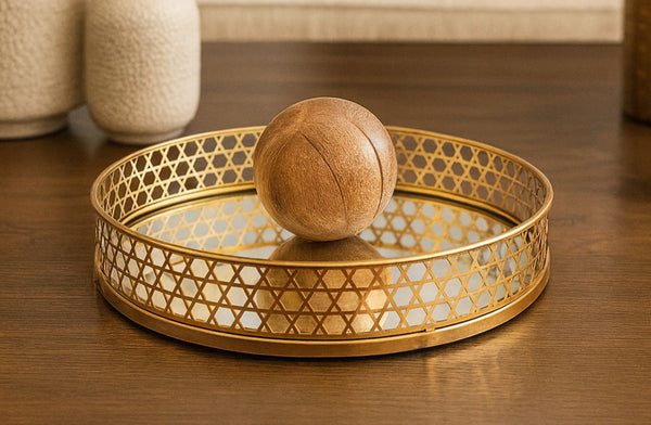 Decorative gold tray with a wooden ball on a wooden surface