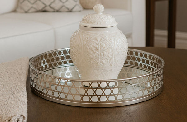 Decorative white jar on a mirrored round tray with a patterned background