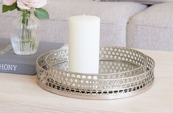 Decorative metal silver tray set with a candle and vase on a table
