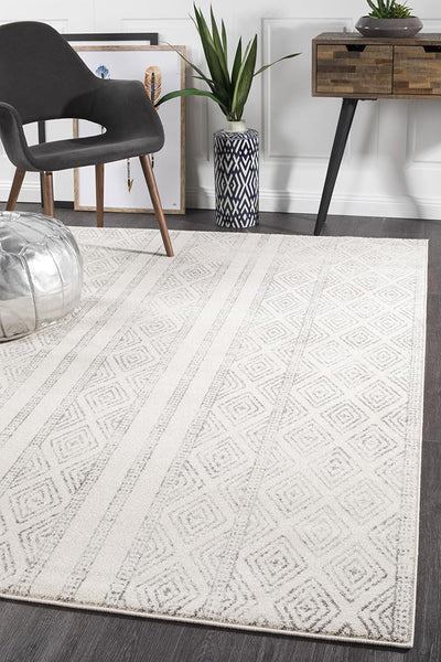 Oasis 450 Grey Rug styled in a modern living space with a black chair, plants, and a wooden console table.