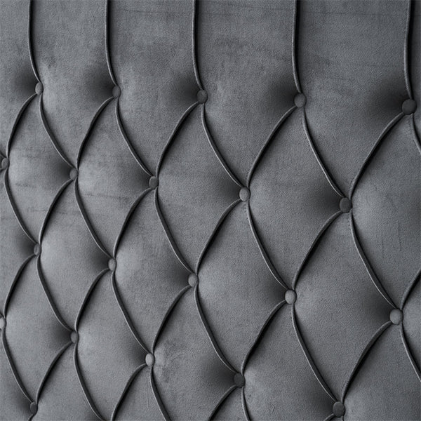 Dark grey tufted velvet headboard close-up.