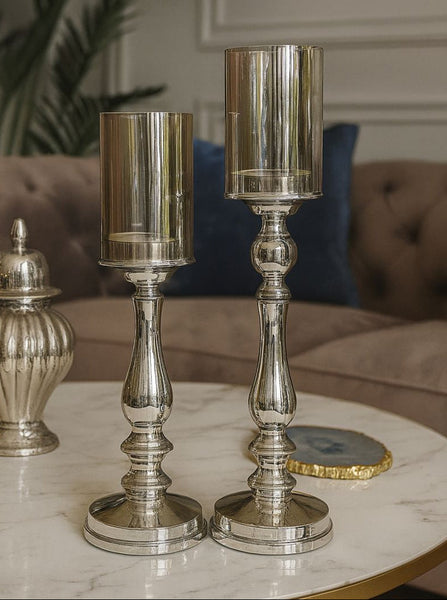 Silver candle holders on a marble surface with a blurred background