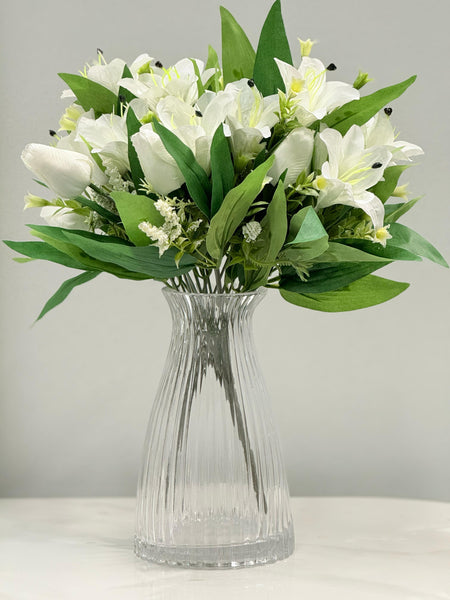 Clear ribbed glass vase, 20cm height, styled with a bouquet of white artificial flowers and green foliage.