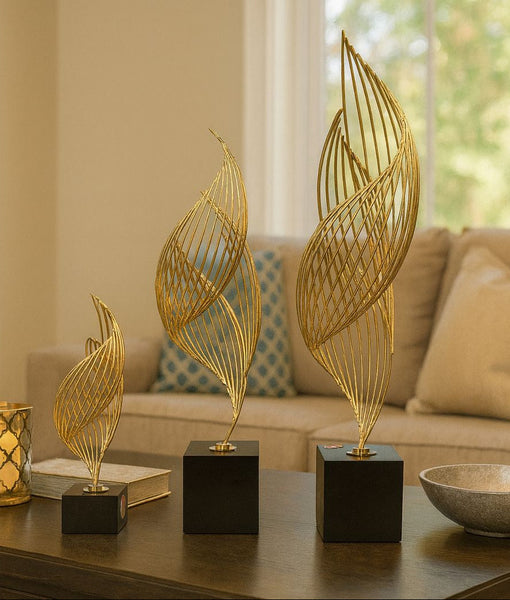 Decorative gold leaf sculpture set on a coffee table in a living room setting.