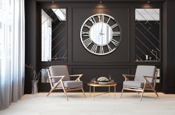 Extra-large silver mirrored Roman numeral clock styled in luxury sitting area, elegant statement.