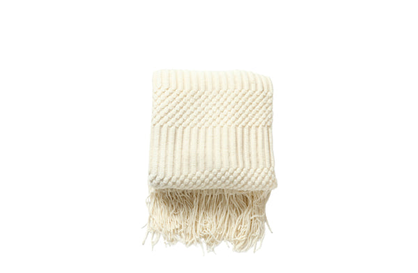 Cream Tessa throw rug blanket with a soft textured weave and fringe edges.