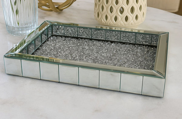 Decorative rectangular mirror tray with a grid pattern on a light surface.