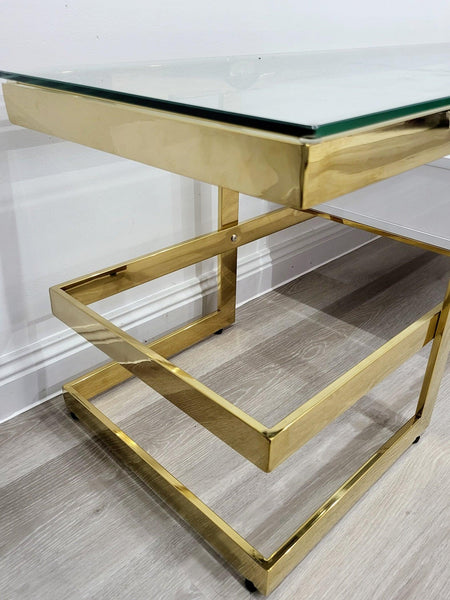 Close-up of Alexa TV Unit showing polished gold stainless steel frame and glass top detail.