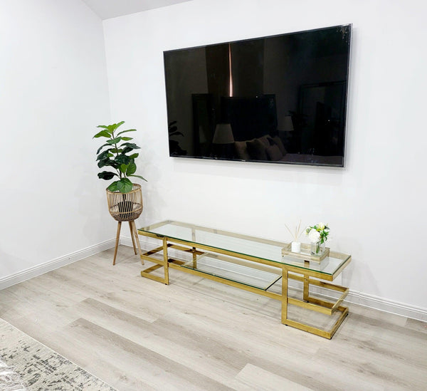 Alexa TV Unit gold frame with clear glass styled with décor under mounted television