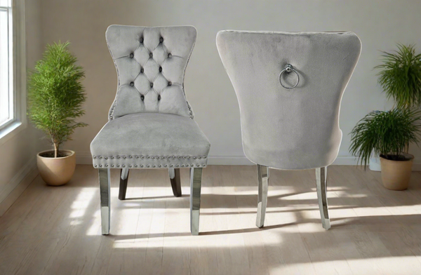 Alsea light grey velvet dining chairs with tufted back, stud trim, ring handle, and silver legs styled in a modern dining room