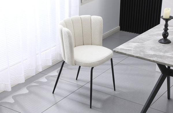 Amelia off-white boucle dining chair with black legs styled beside a dining table in a modern setting.