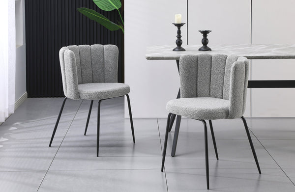 Pair of Amelia grey boucle dining chairs with black legs styled beside a marble dining table.