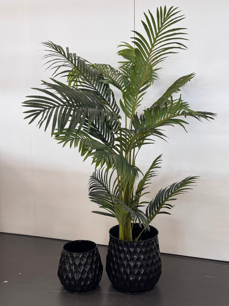 Artificial palm plant styled in black pot for tropical interior vibe.